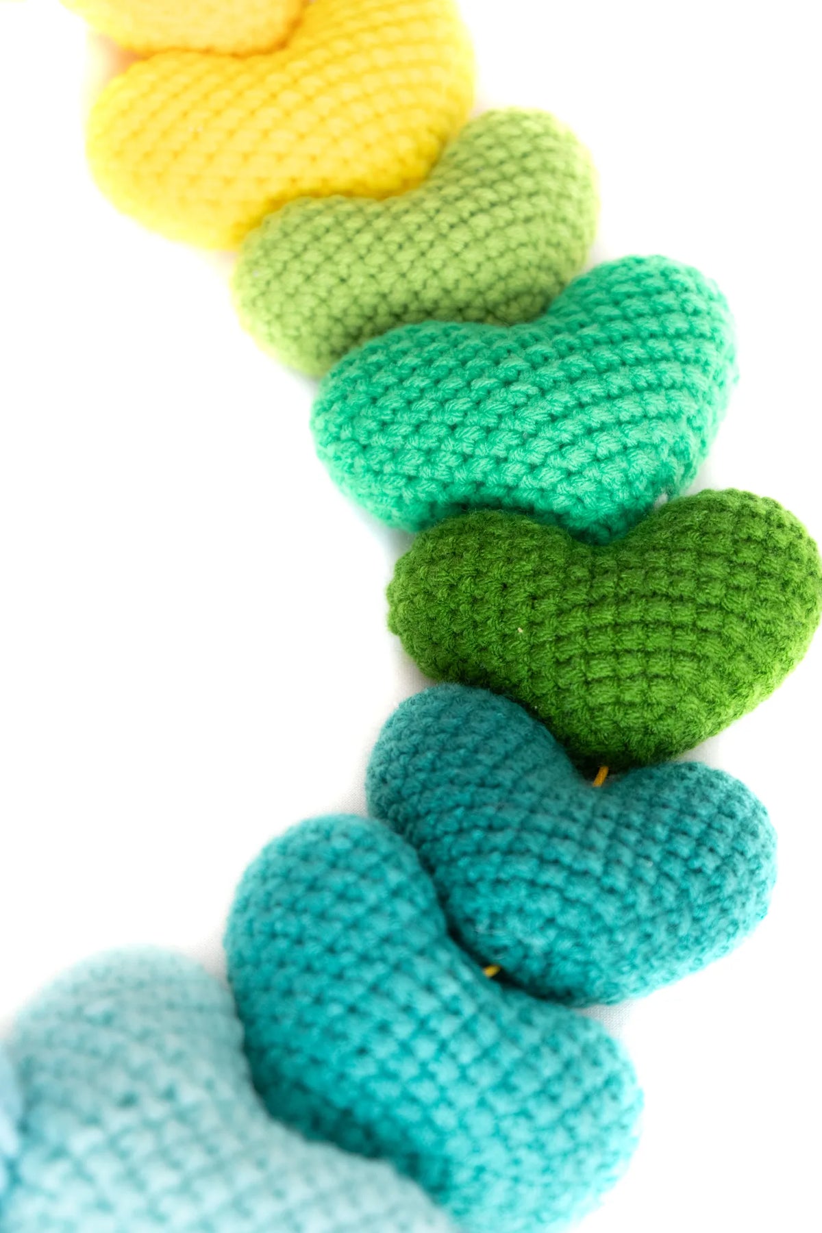 Detail of the oversized yellow, green and teal crochet hearts