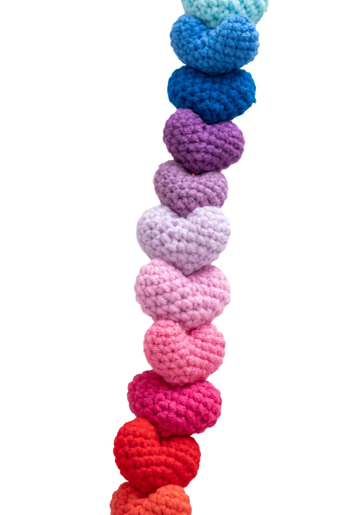 Detail of small blue, lilac, pink and red crochet hearts