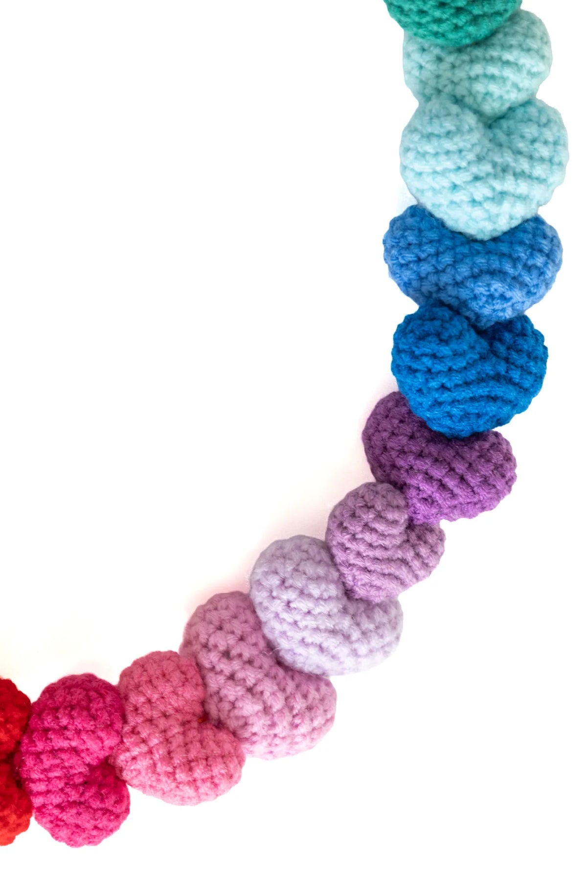 Detail of small pink, purple and blue crochet hearts